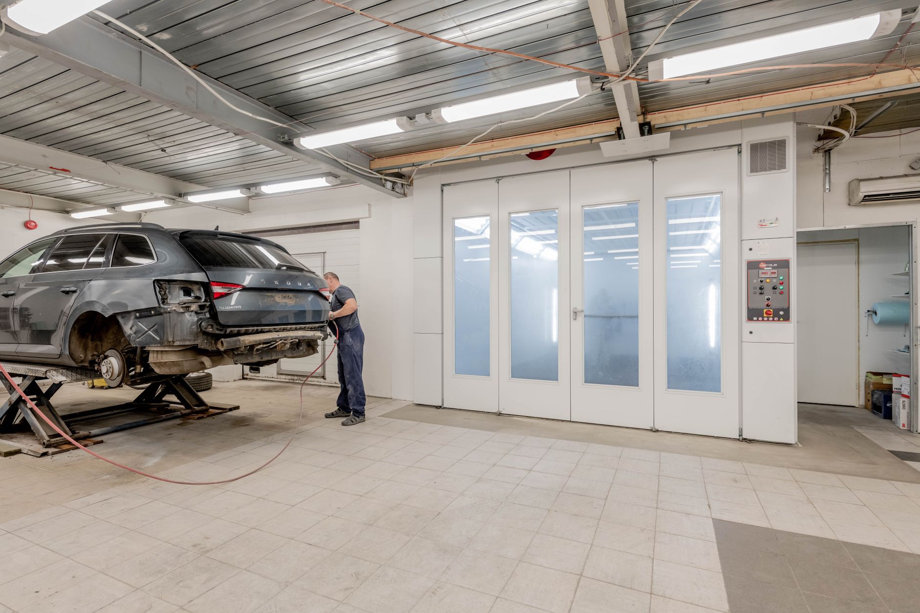 Tekniker vurderer overfladen på et bilpanel